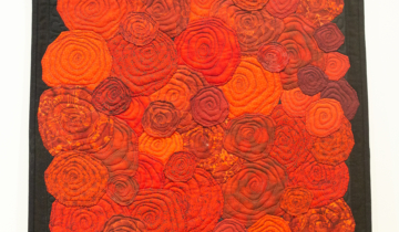 Cathie Ugrin, red spiral rose pattern quilted tapestry